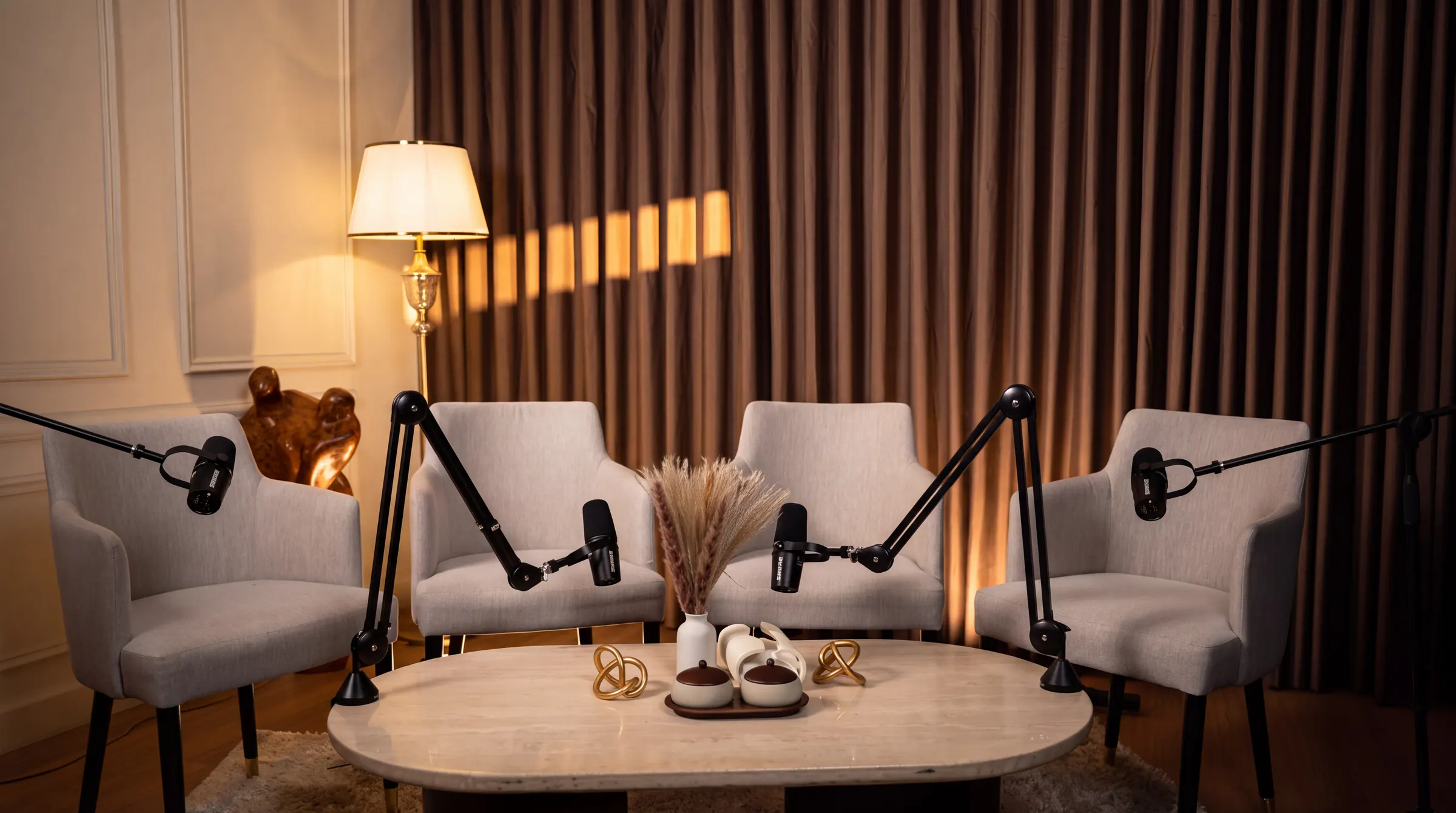 Four-seat panel podcast set with bouclé armchairs around the studio table — Podflix Studio, Business Bay Dubai