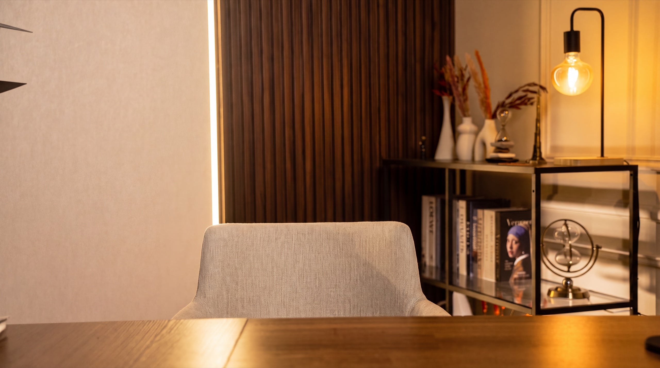 Clean solo podcast table set against the slatted wall and bookshelf — Podflix Studio Dubai